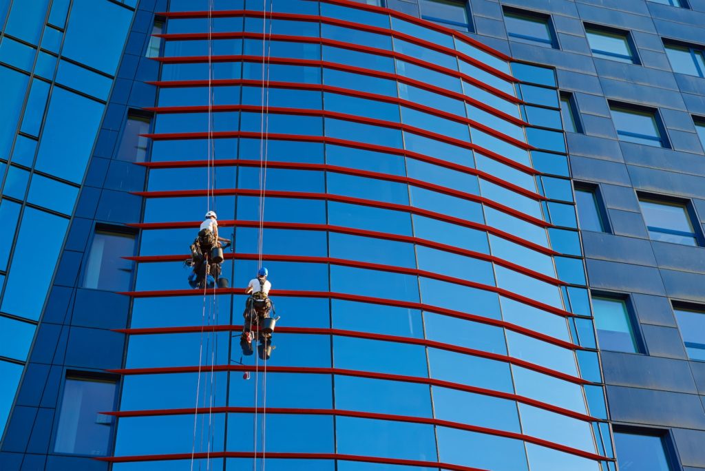 Workers cleaning windows in business center in scyscraper